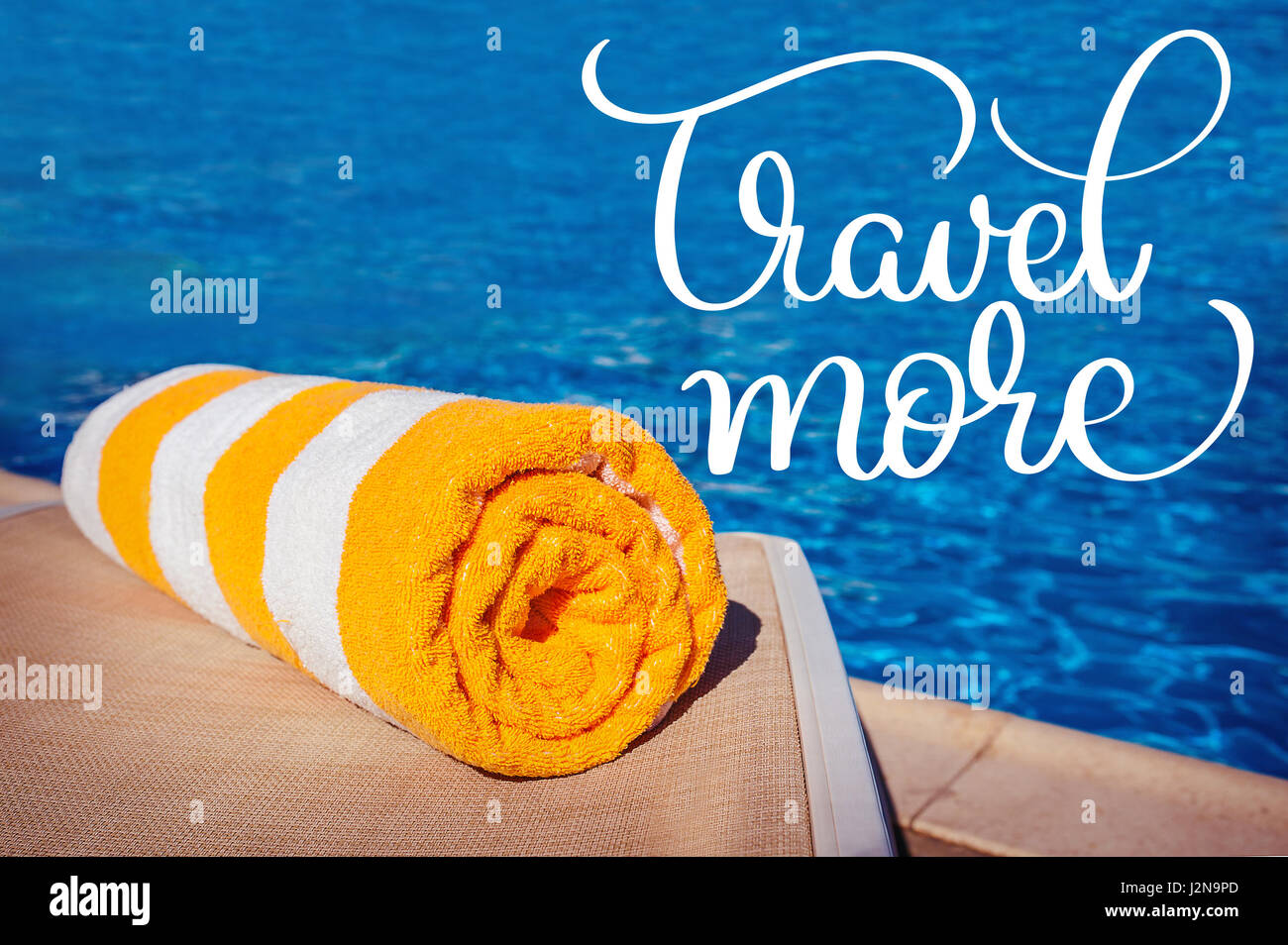 towel on a background of pool and text Travel more. Calligraphy lettering hand draw Stock Photo