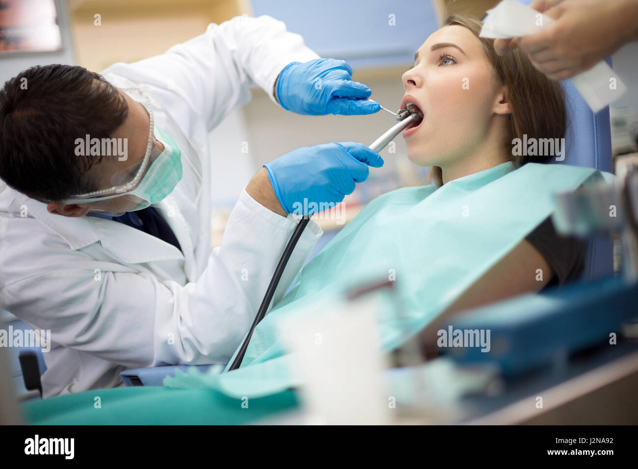 Dentist put dental mirror and drill in patient mouth Stock Photo - Alamy