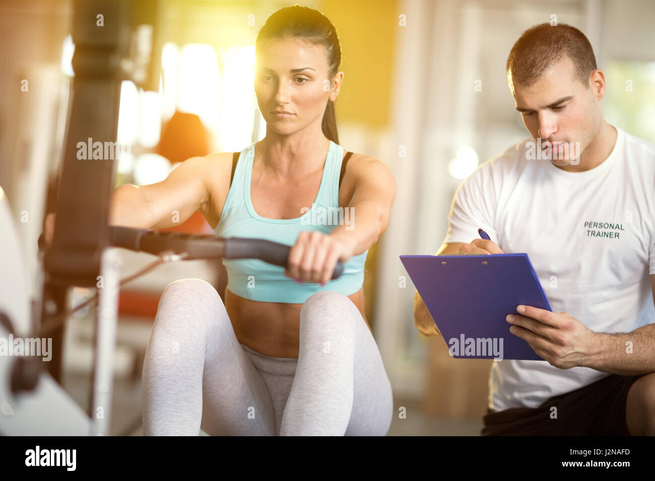 Gym woman and her trainer doing exercise at the gym. Stock Photo
