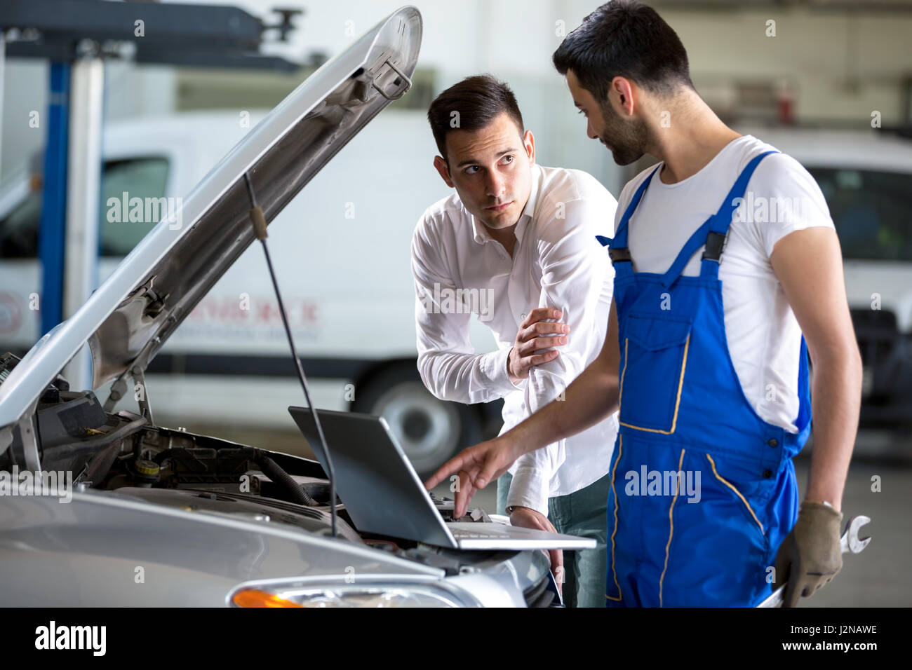mechanic working on laptop computer with customer Stock Photo - Alamy