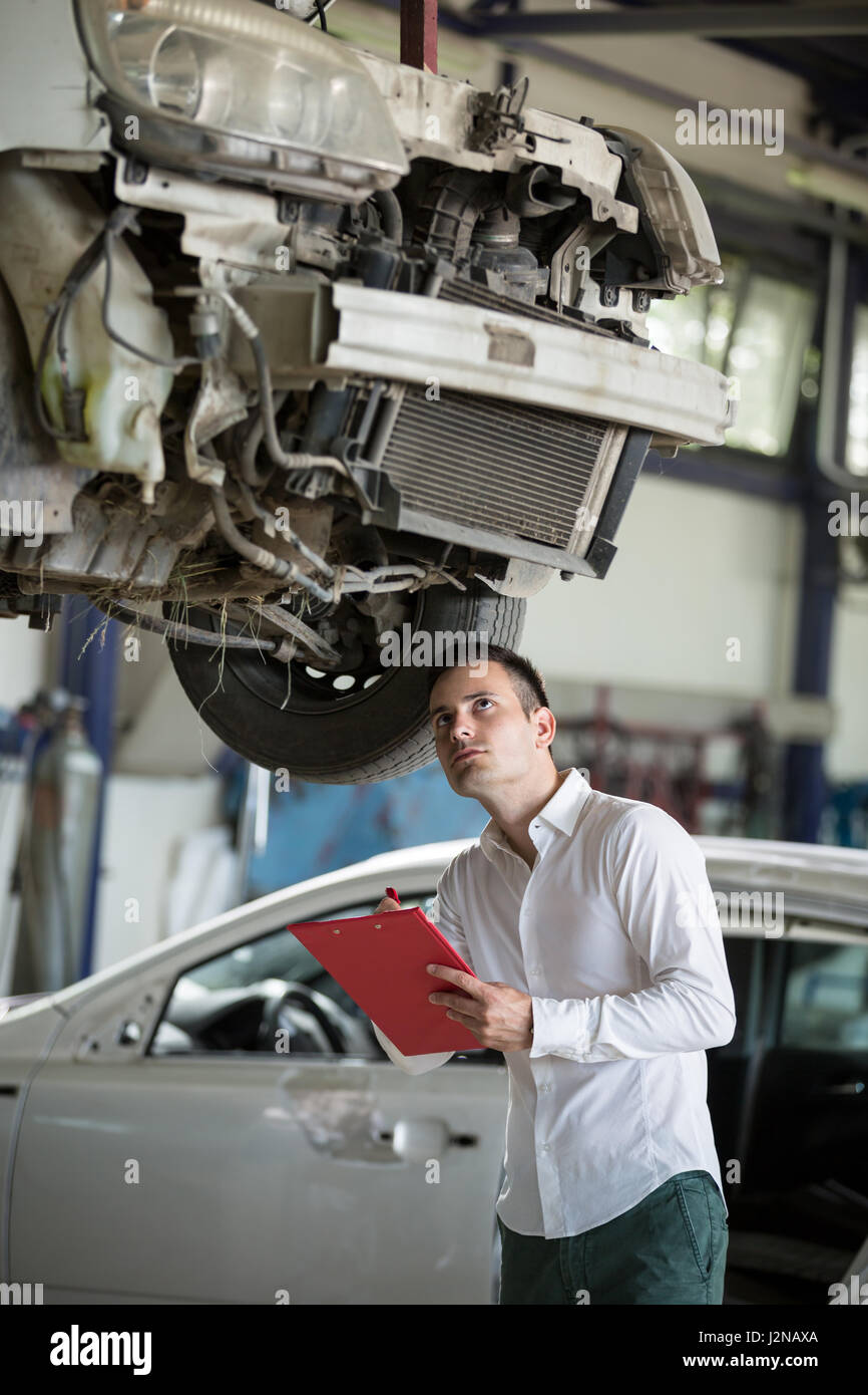 insurance agent writing on clipboard assessment on car damage Stock Photo
