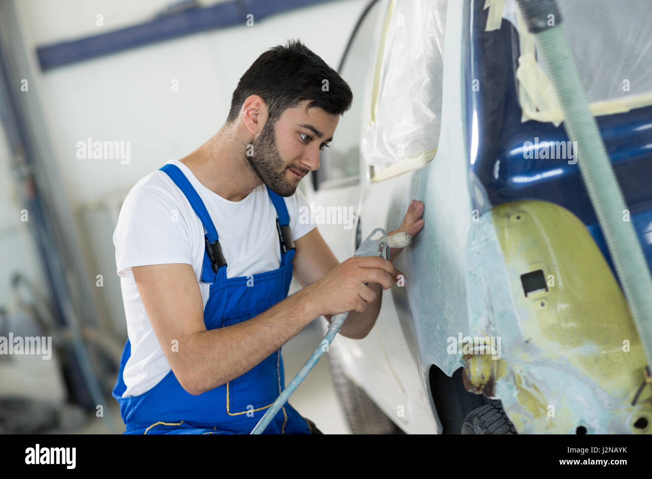 Worker prepare body part for paint in service Stock Photo Alamy