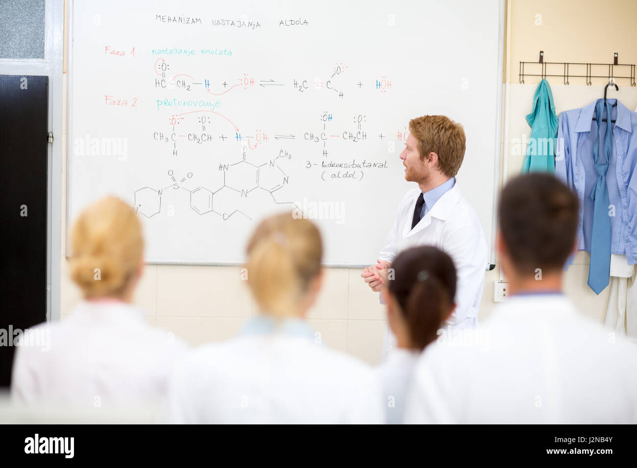 Young male chemical teacher teaching students in the classroom Stock Photo