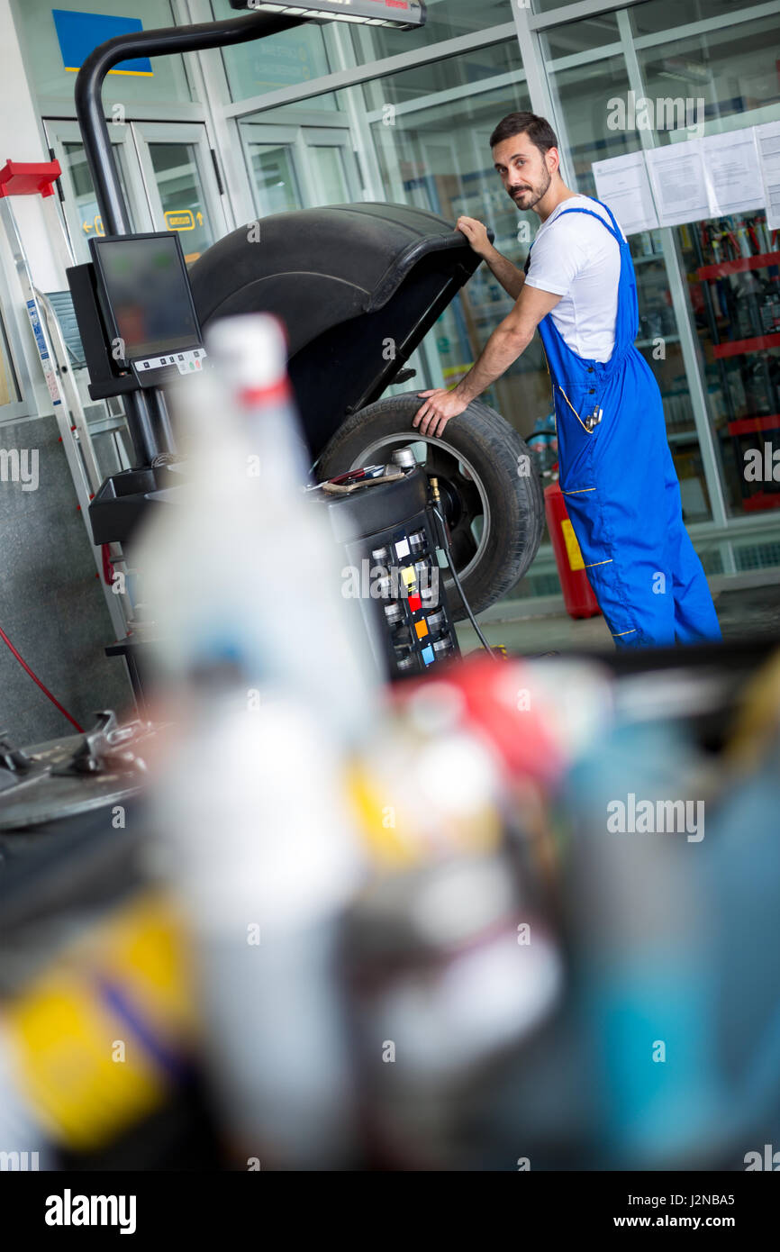 car mechanic working with machine balancer at the repair garage Stock ...
