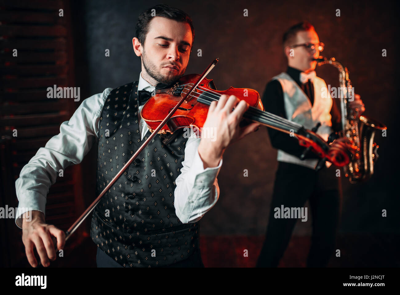 Jazz man and violinst, classical musical duet. Sax and fiddle music players Stock Photo