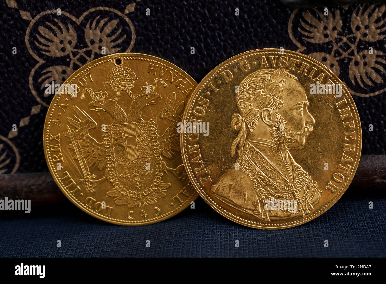 Close-up view of two on one another Austria-Hungary thalers, avers and revers of golden coin-ducats from 1915 with Kaiser Franz Joseph I Stock Photo