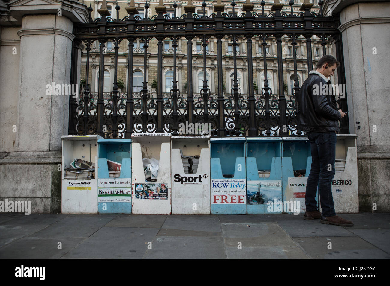 Man in front of free newspaper stand Stock Photo