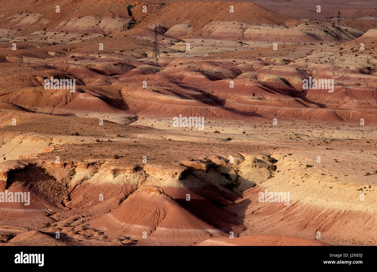 The arid desert landscape and striking geological formations of the Atlas Mountains in Morocco near the world heritage site of Ait Benhaddou. Stock Photo