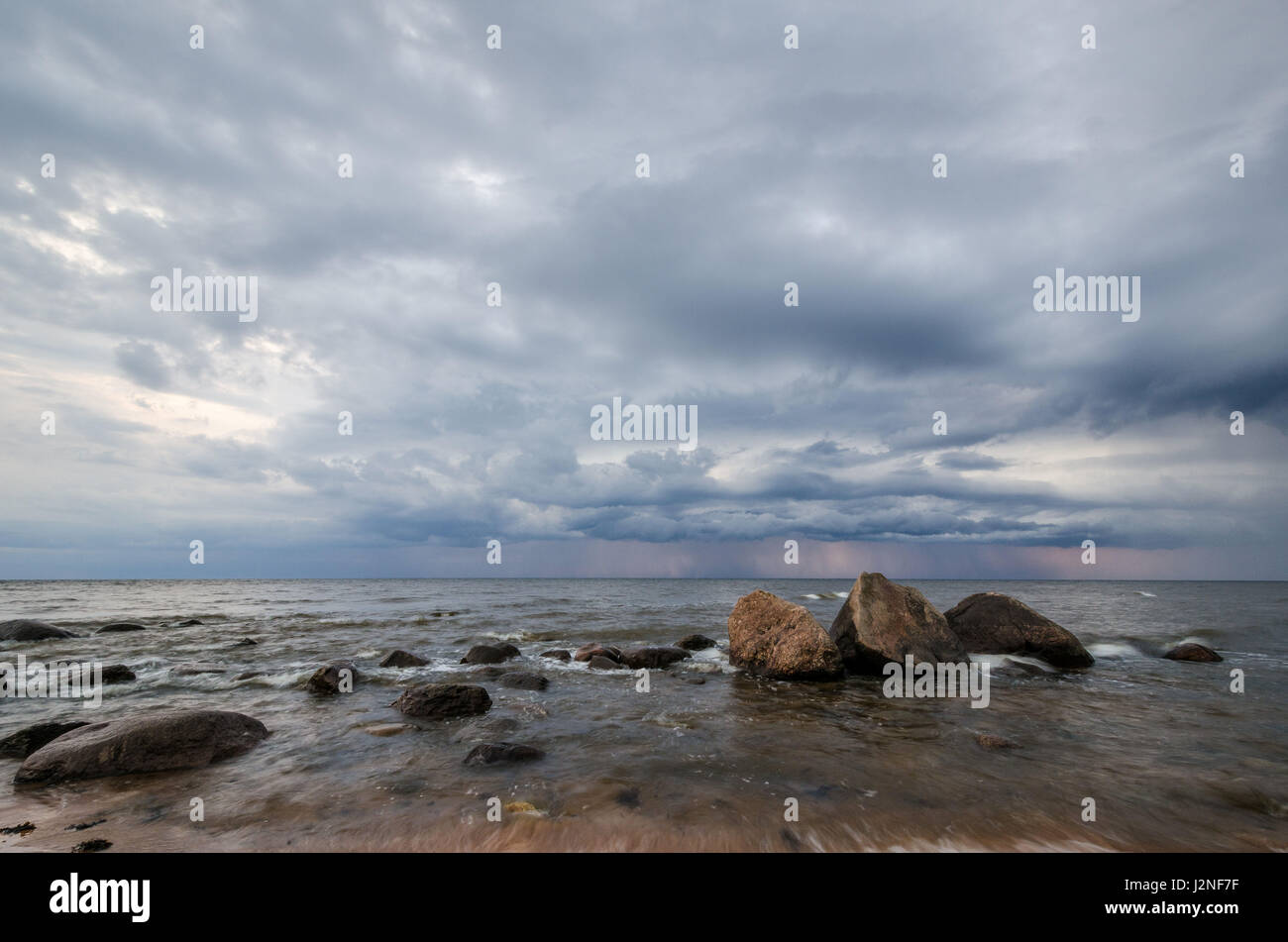 Seascape. Storm clouds gathering over the rocky beach Stock Photo - Alamy