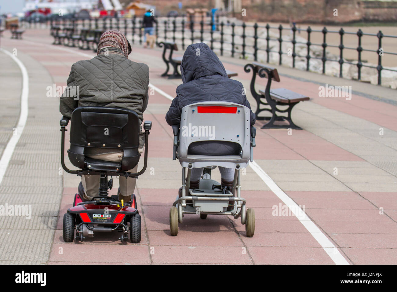 Wheelchair users at New Brighton, Wallasey, UK.  UK Weather.  30th April, 2017. Sunny with gusty winds in the resort and light windborne sand causing irritation to tourists enjoying the beach promenade at low water. Credit; MediaWorldImages/AlamyLiveNews Stock Photo