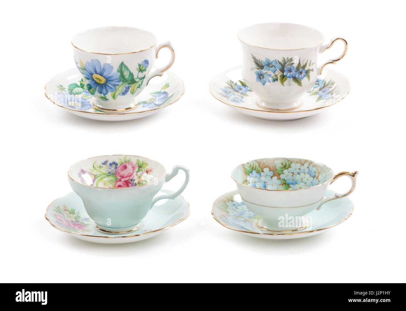 High resolution close-up of four beautiful antique tea cups with saucers isolated on a white background. Stock Photo