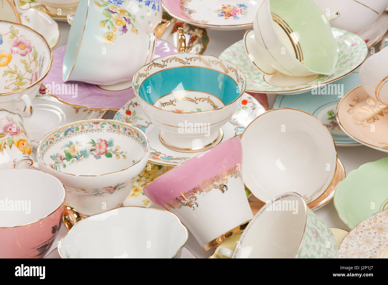 High resolution close-up of a beautiful antique tea cups and saucers collection, isolated on a white background. Stock Photo