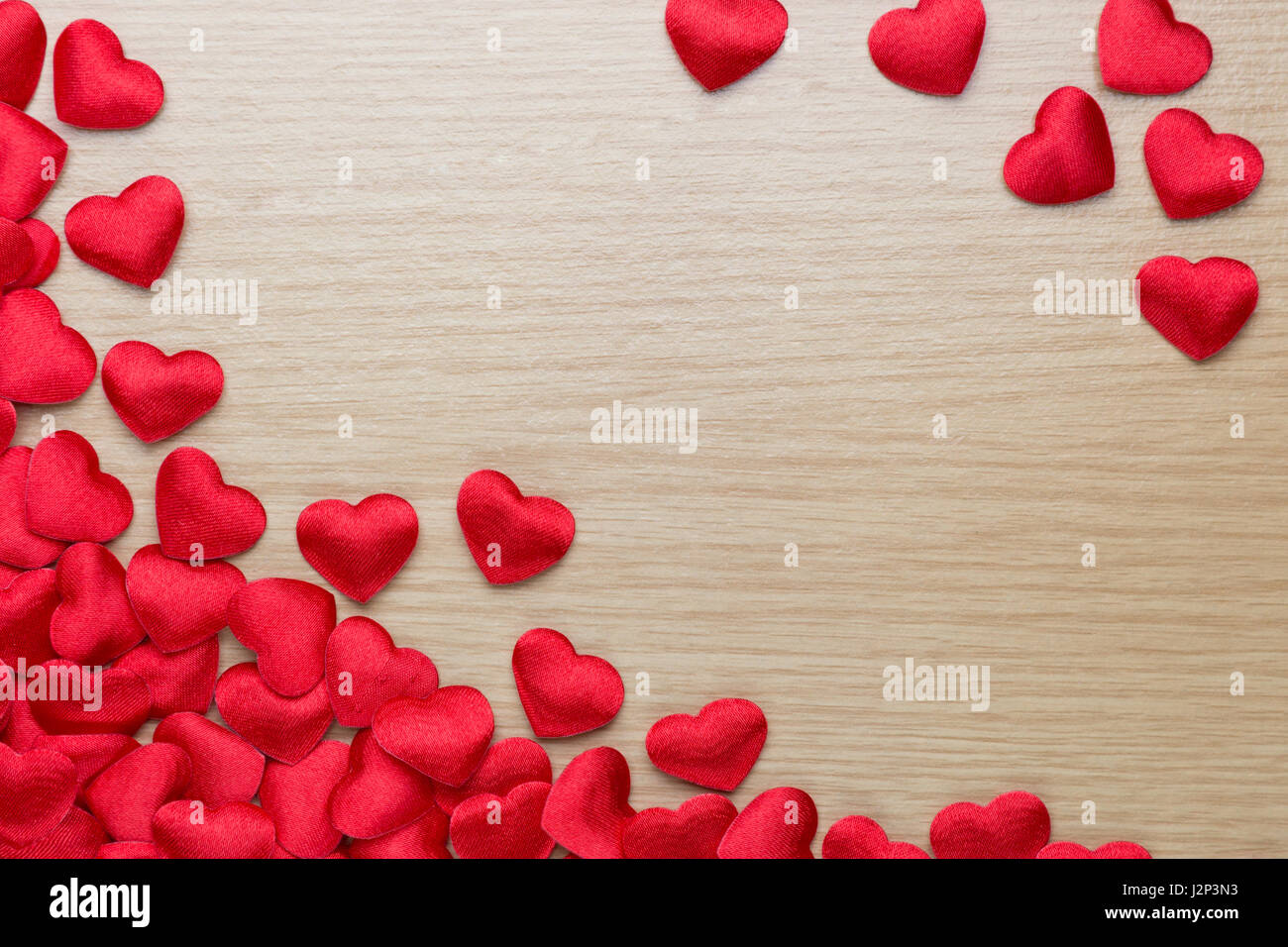 Small red hearts gather on wood table with space for text, good for valentine's day or special occasions Stock Photo