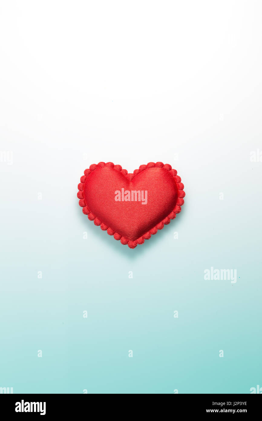 Small single red heart made of fabric on gradated white to light blue background, lots of usable space for text Stock Photo