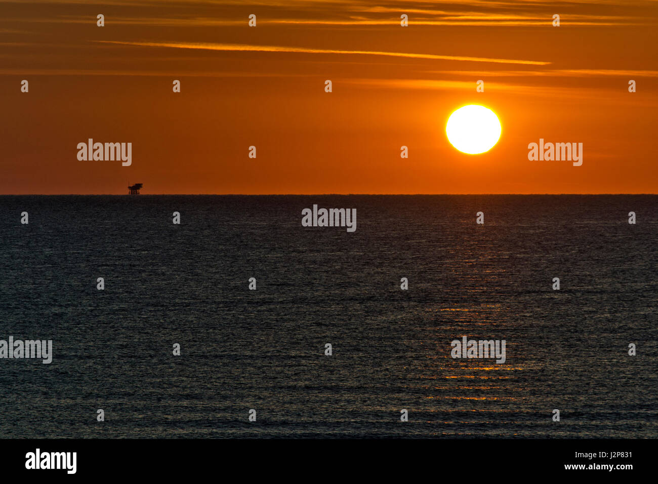 sunrise with sun and oil platform Stock Photo