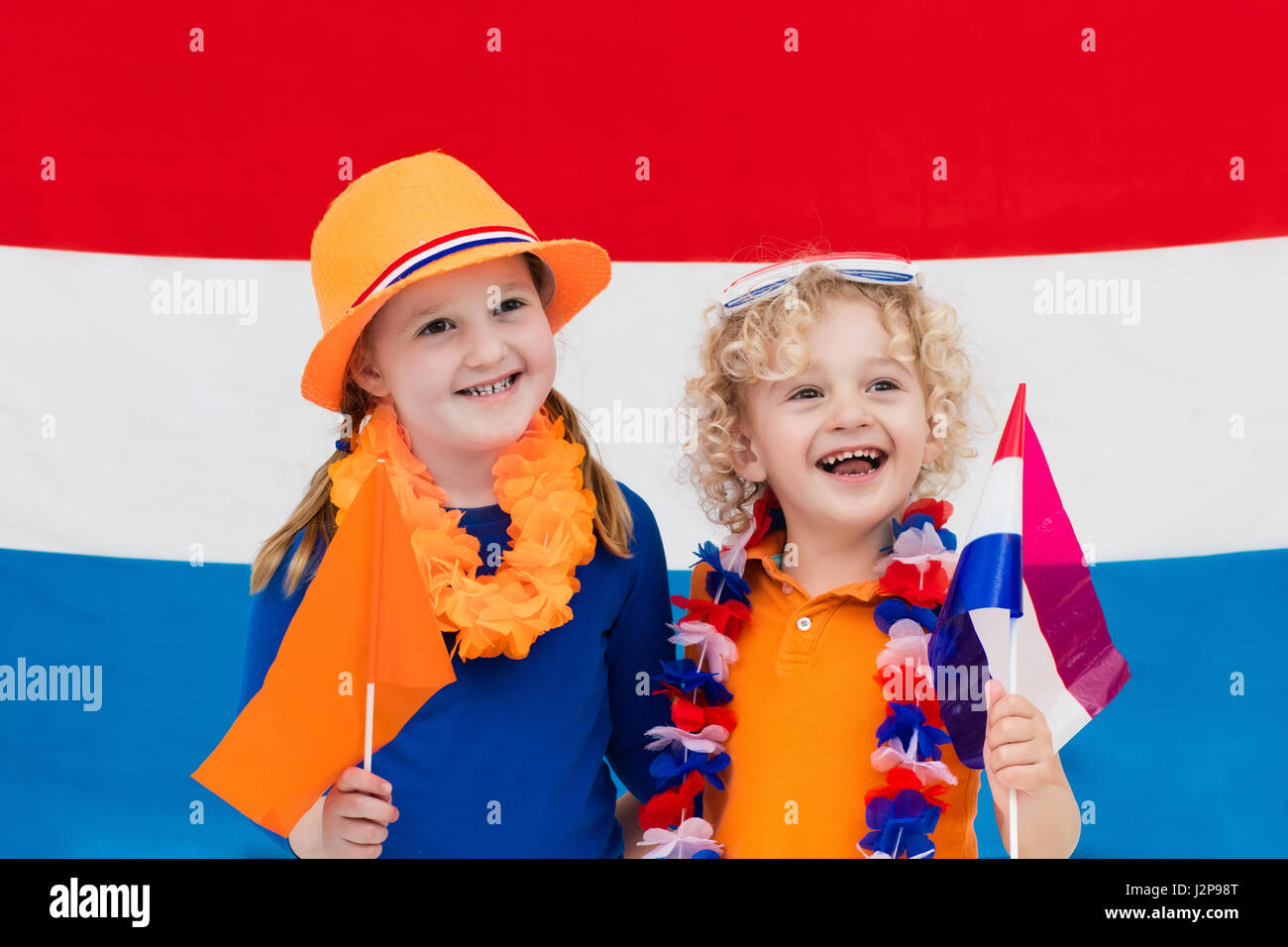 Little Dutch boy and girl wearing country symbols celebrating King day. Children support Holland sport team. Kids from the Netherlands. Young sport fa Stock Photo
