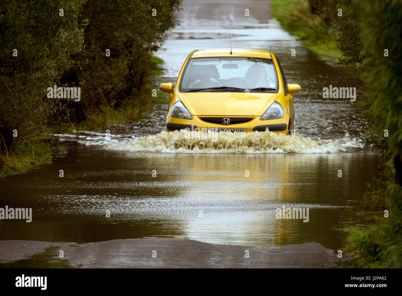 16th July 2012 - Vehicles driving through the flooding on the Somerset Levels on the road between Glastonbury and Godney Stock Photo