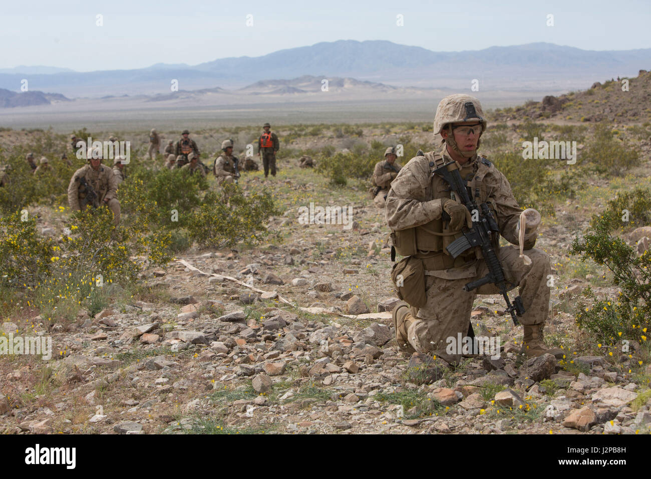 U.S. Marines with Golf Company, 2nd Battalion, 6th Marine Regiment, 2nd Marine Division (2d MARDIV), await the breach of simulated enemy concertina wire during company-level attack live fire training at Range 400 for Talon Exercise (TalonEx) 2-17, Marine Corps Air Ground Combat Center, Twentynine Palms, C.A., April 9, 2017. The purpose of TalonEx was for ground combat units to conduct integrated training in support of the Weapons and Tactics Instructor Course (WTI) 2-17 hosted by Marine Aviation Weapons and Tactics Squadron One (MAWTS-1). (U.S. Marine Corps photo by Lance Cpl. Tojyea G. Matall Stock Photo