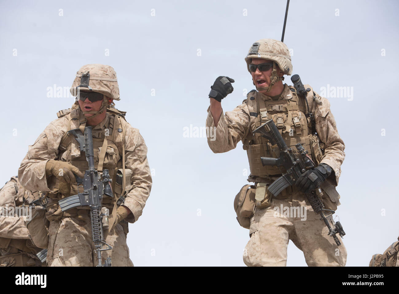 U.S. Marine Corps 2nd Lt. Hugo J. Jury, right, a platoon commander with Golf Company, 2nd Battalion, 6th Marine Regiment, 2nd Marine Division (2d MARDIV), calls out commands to his platoon during company-level attack live fire training at Range 400 for Talon Exercise (TalonEx) 2-17, Marine Corps Air Ground Combat Center, Twentynine Palms, C.A., April 9, 2017. The purpose of TalonEx was for ground combat units to conduct integrated training in support of the Weapons and Tactics Instructor Course (WTI) 2-17 hosted by Marine Aviation Weapons and Tactics Squadron One (MAWTS-1). (U.S. Marine Corps  Stock Photo