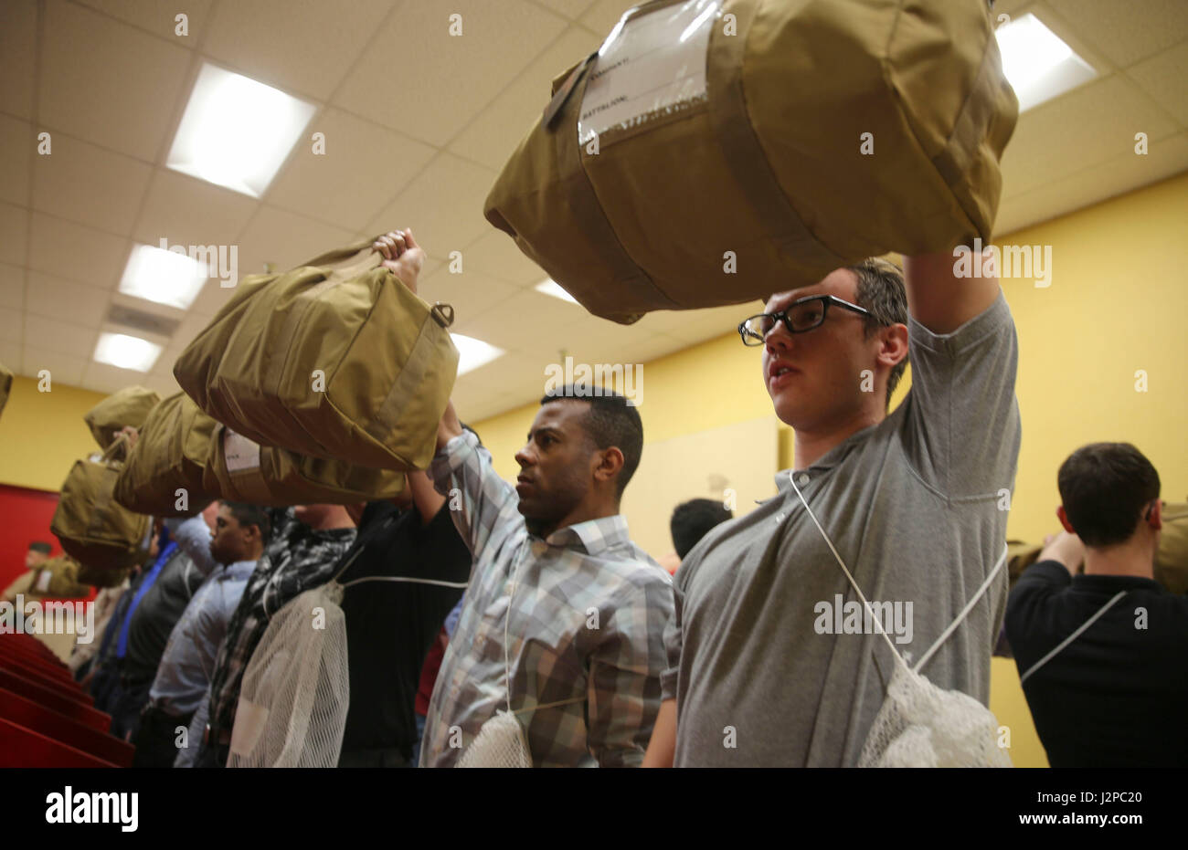 Recruits from Hotel Company, 2nd Recruit Training Battalion, hold up their war bags during receiving at Marine Corps Recruit Depot San Diego, April 17. The war bags are part of the recruits’ initial gear, and they will receive the rest of their gear at the end of the week. Annually, more than 17,000 males recruited from the Western Recruiting Region are trained at MCRD San Diego. Hotel Company is scheduled to graduate July 14. Stock Photo