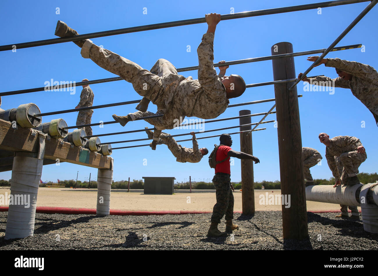 Recruits from Delta Company, 1st Recruit Training Battalion, maneuver a high obstacle during Obstacle Course II at Marine Corps Recruit Depot San Diego, April 20. The recruits were allowed to complete the obstacle by sliding down under a single bar or by pulling themselves up and sliding down two bars. Annually, more than 17,000 males recruited from the Western Recruiting Region are trained at MCRD San Diego. Delta Company is scheduled to graduate June 30. Stock Photo