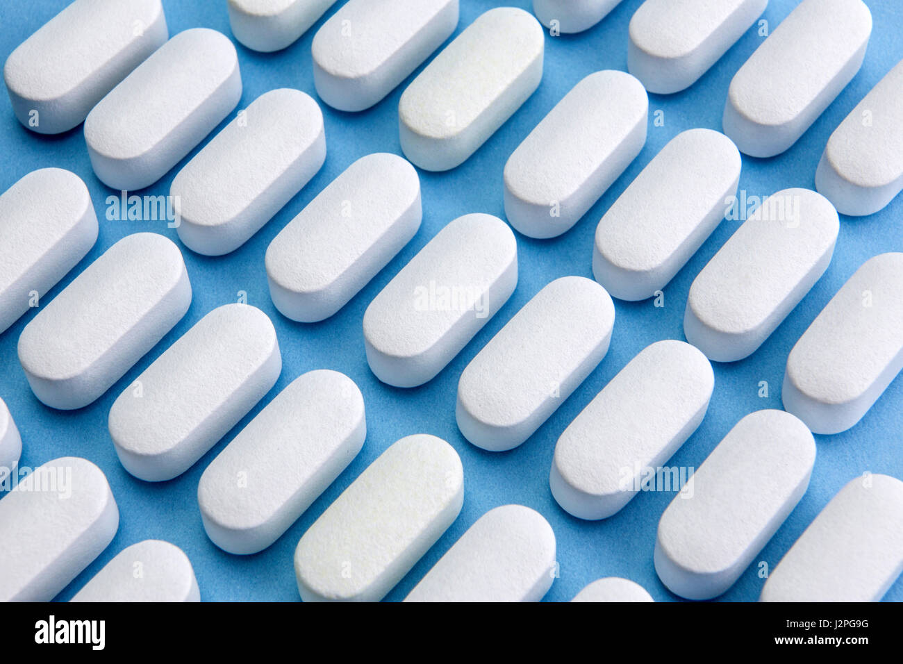 Some pills aligned isolated on blue background Stock Photo
