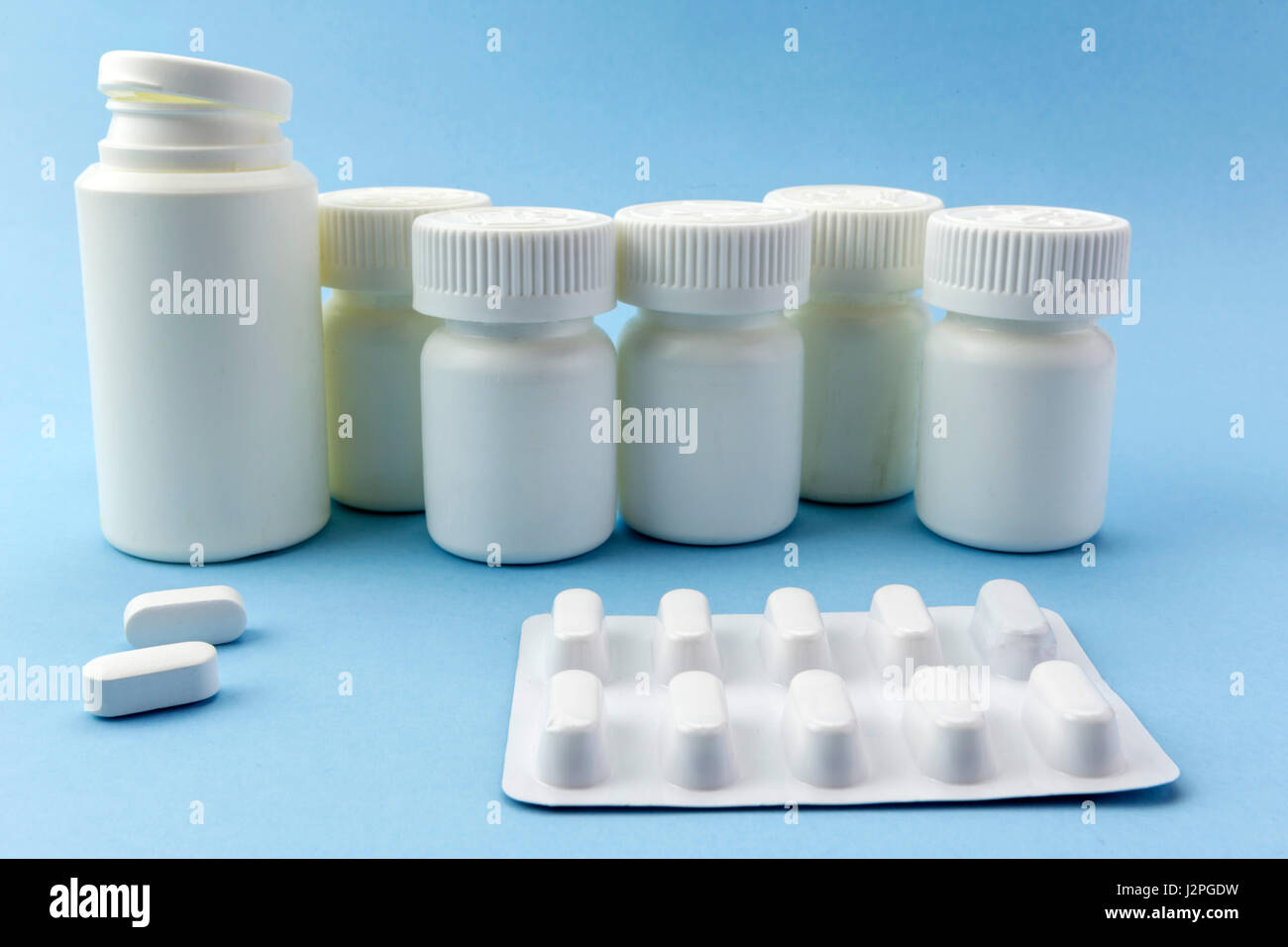 Pills boats white with white tablets of different types on blue background Stock Photo