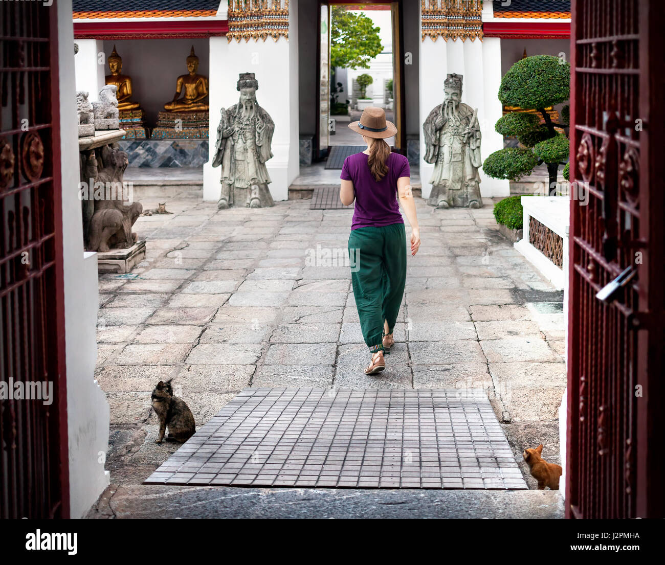 Woman tourist near Ancient Royal Stupas and pagoda in Wat Pho temple in Bangkok at sunset Stock Photo