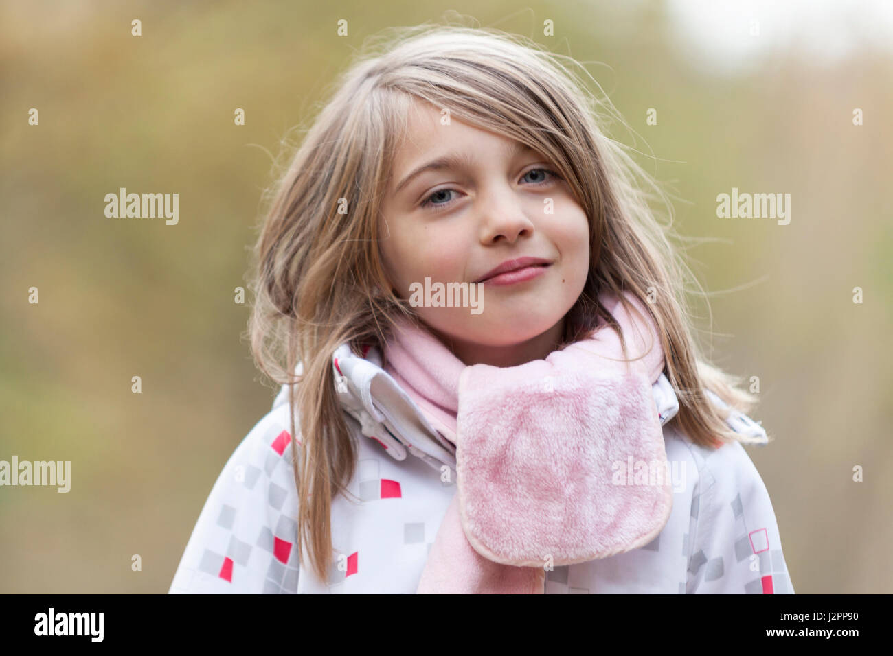 Close up portrait of happy smiling young girl outdoors in warm clothing ...