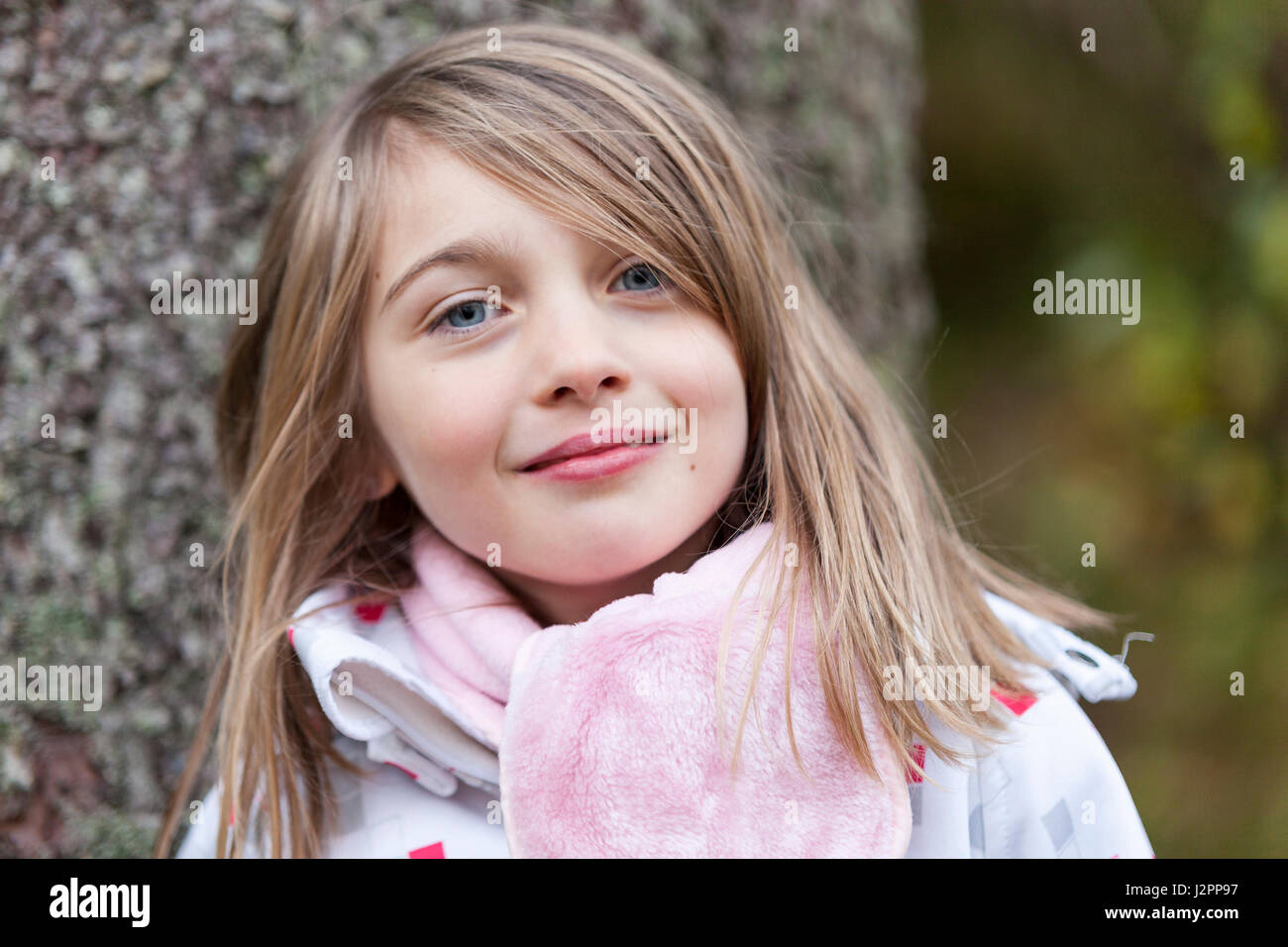 Close up portrait of happy smiling young girl outdoors in warm clothing ...