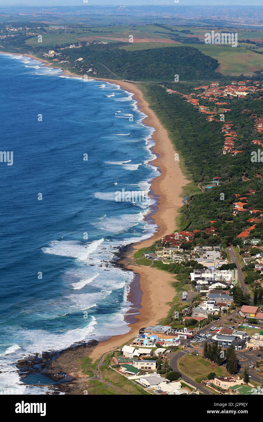 An aerial perspective of waves breaking along a rocky shoreline in an urban setting. Stock Photo