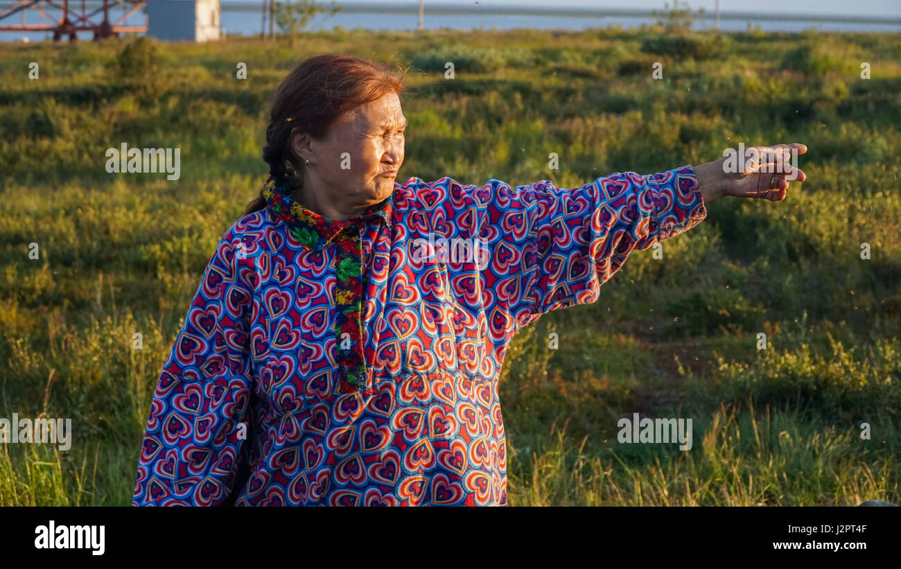 Nenets woman in the tundra hand indicates the direction away. Summer Stock Photo