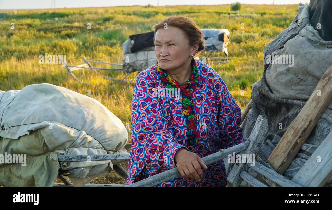 Nenets woman outside near the tent, gazing into the distance. Summer Stock Photo