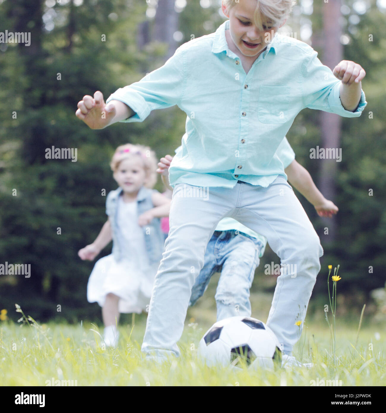 Happy children playing football in summer park Stock Photo - Alamy