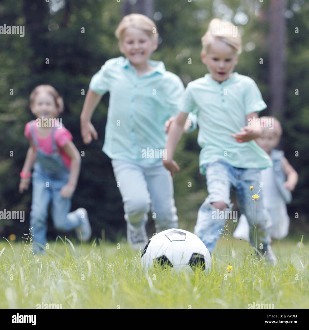 Happy children playing football in summer park Stock Photo - Alamy