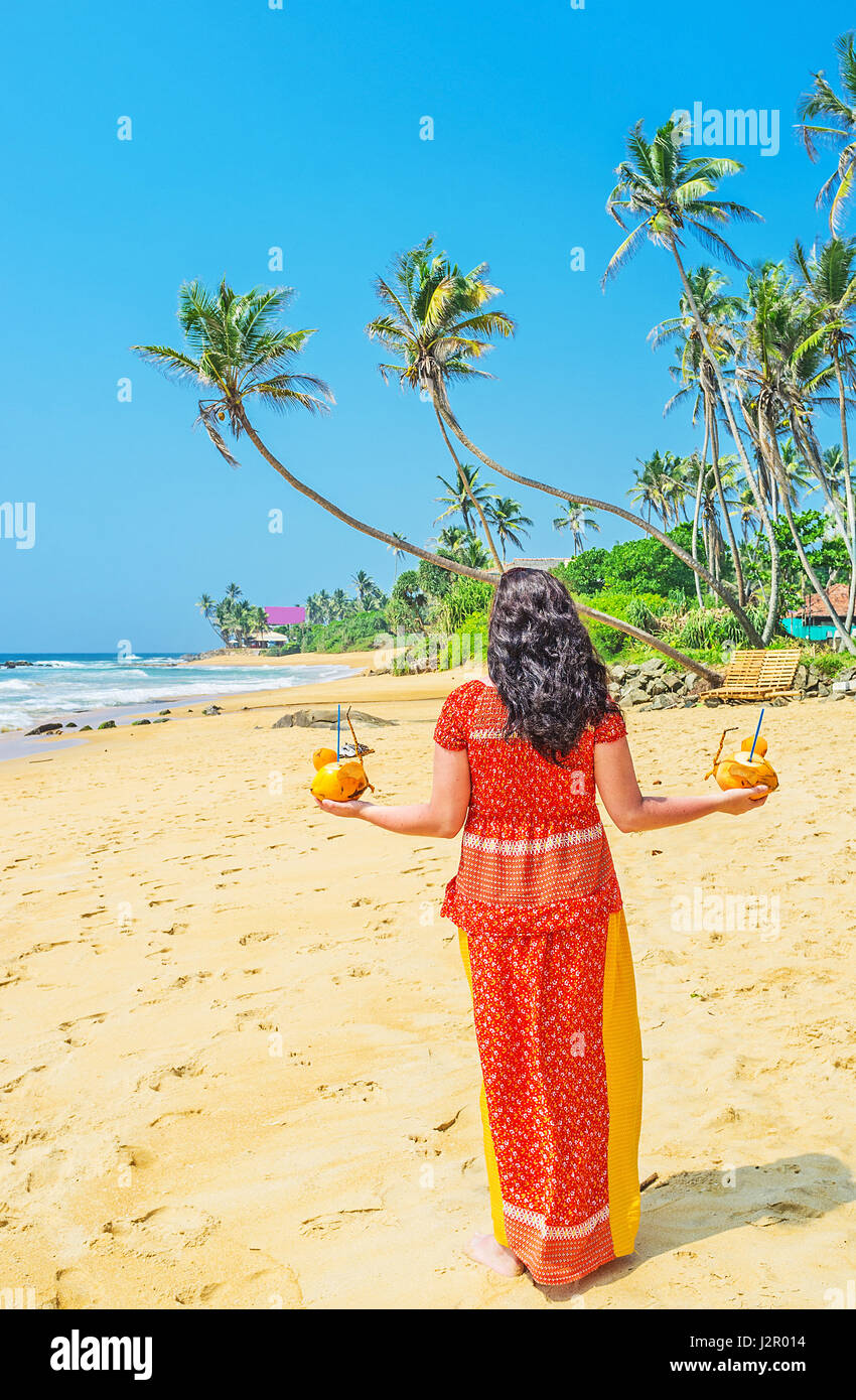 The girl walks along the Boosa beach with coconut mice, full of fresh
