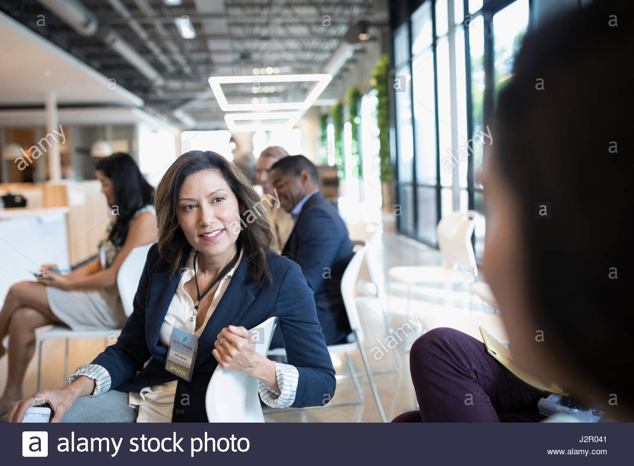 Smiling Latina Businesswoman Talking To Colleague In Conference Audience Stock Image Smiling Latina Businesswoman Talking To Colleague In Conference Audience Stock Image