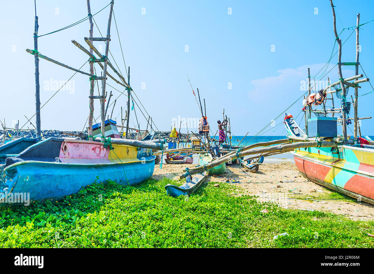 HIKKADUWA, SRI LANKA - DECEMBER 4, 2016: The fisherman in Kumarakanda fishery harbor prepares his oruwa boat to go to the ocean and waits other member Stock Photo