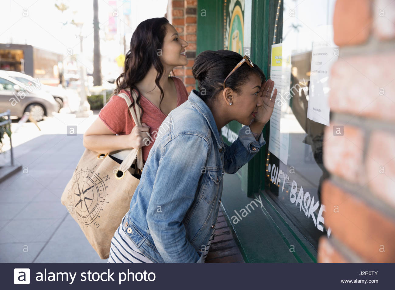 Women friends window shopping at storefront Stock Photo