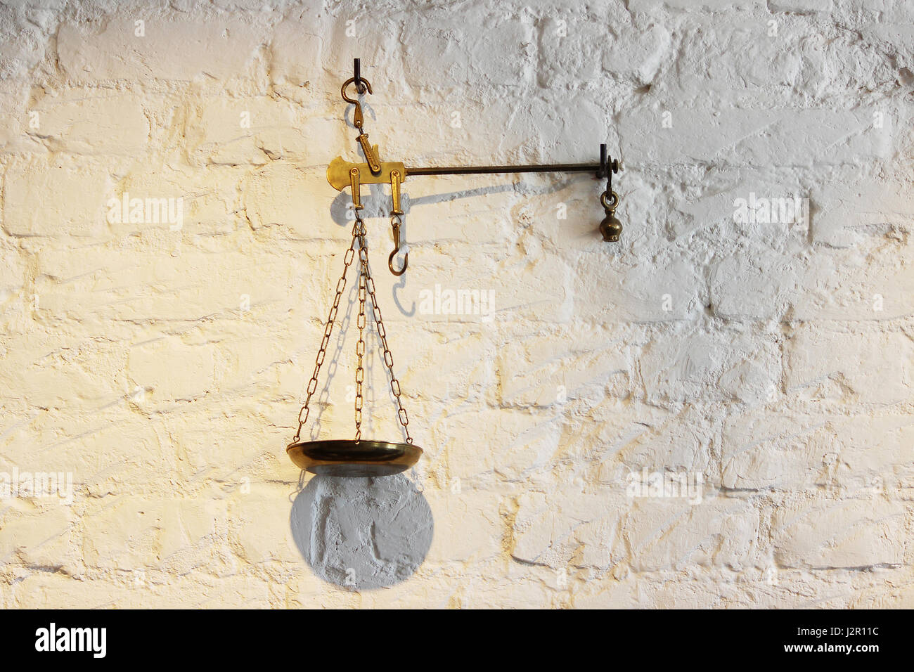 https://c8.alamy.com/comp/J2R11C/the-old-metal-scales-decorate-the-white-wall-J2R11C.jpg