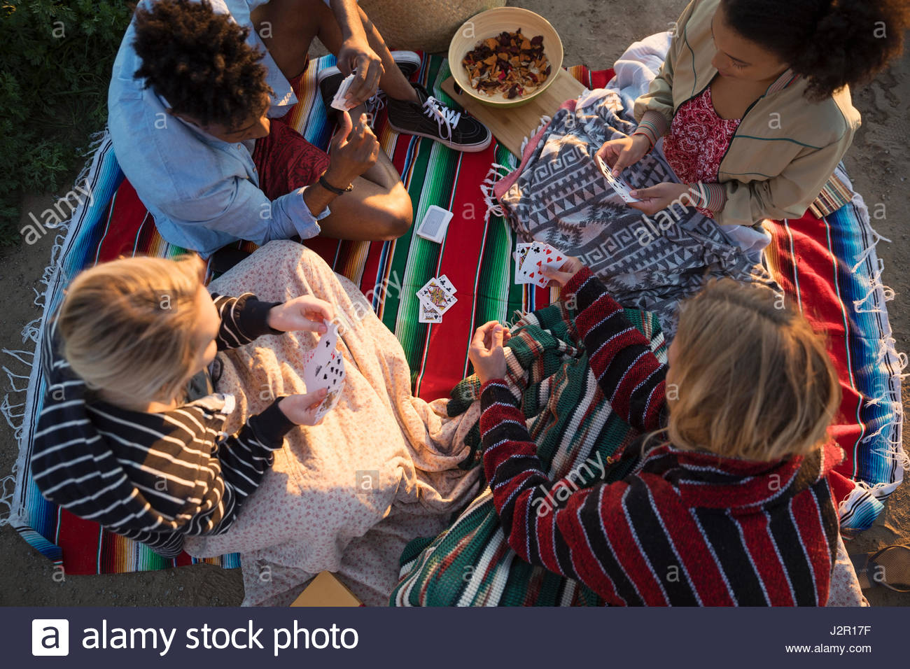 Young friends playing cards on picnic blanket Stock Photo Alamy