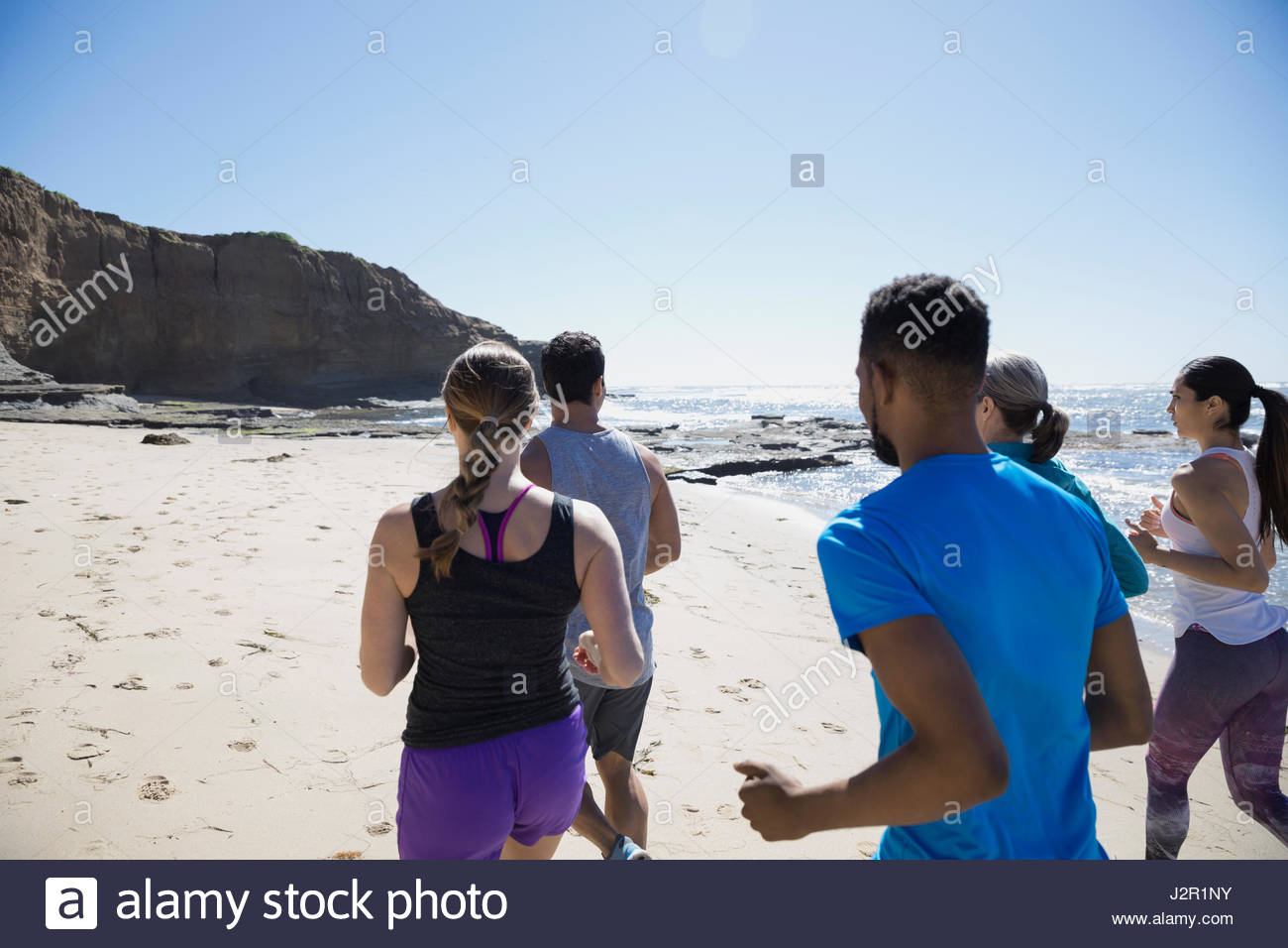 Crossfit class running on sunny beach Stock Photo