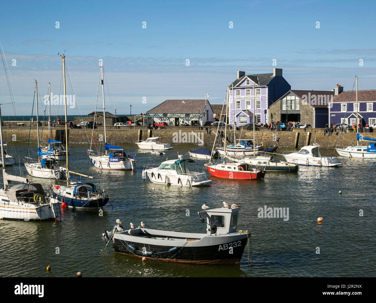The charming Georgian port town of Aberaeron on the Cardigan Bay Coast, Ceredigion, West Wales with sailing boats and fishing boats in the harbour. Stock Photo