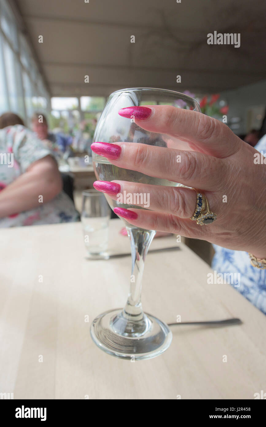 Woman holding a wine glass Painted finger nails Manicured Drinking Hand Stock Photo