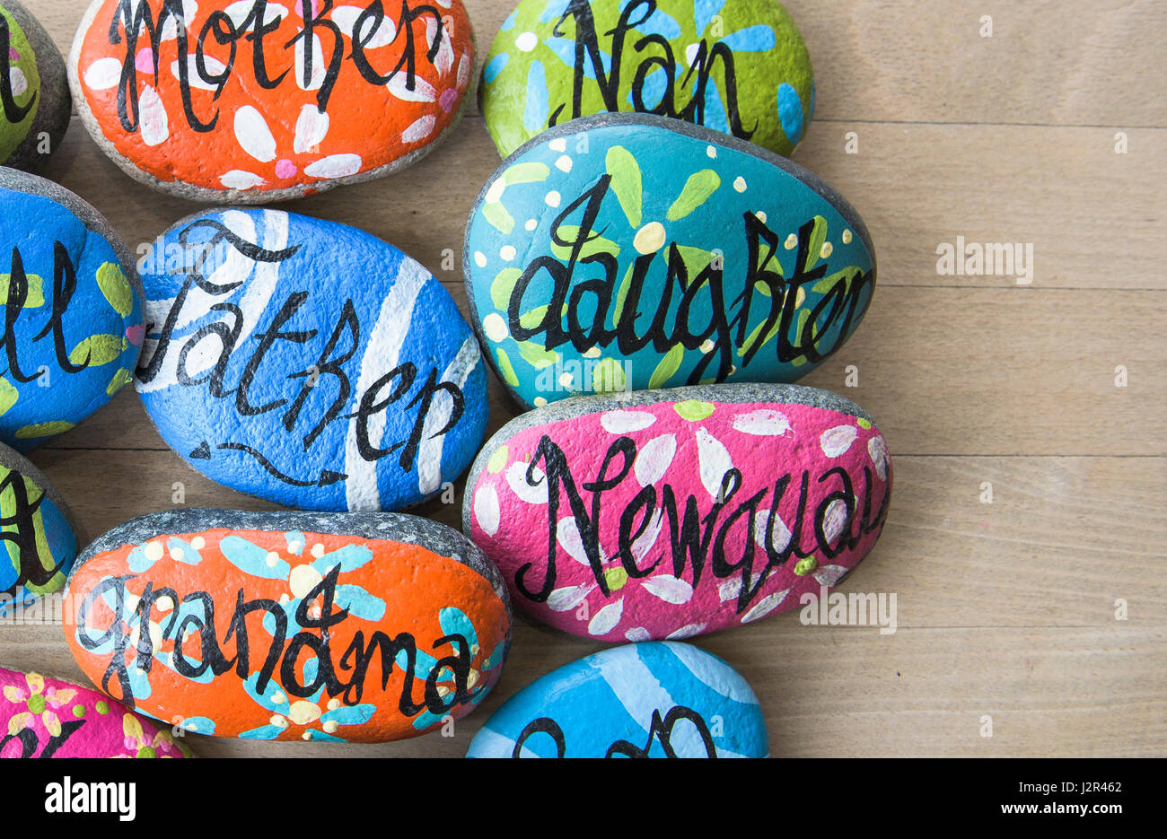 Close up of painted pebbles Painted stones Names Decoration Decorated Place names Colourful Colorful Family Names Pretty Vibrant Stock Photo
