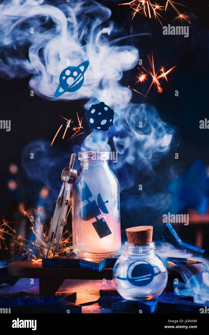 Astronomy themed still life with space station, planets and asteroid inside jars on a dark background Stock Photo