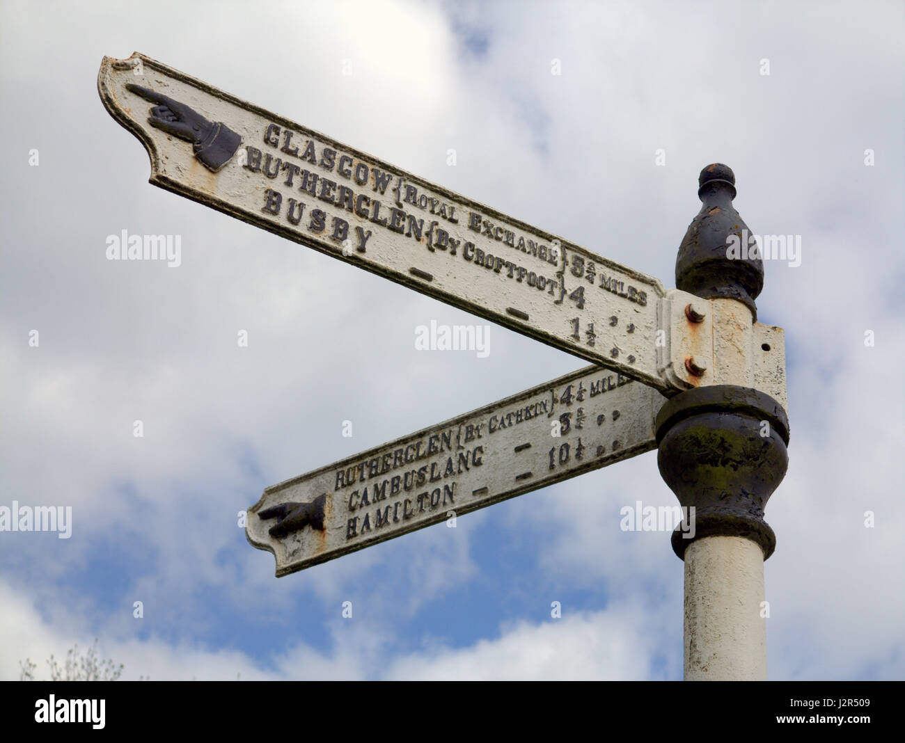 old iron signpost in Carmunock village green near Glasgow pointing to local towns and sites Stock Photo