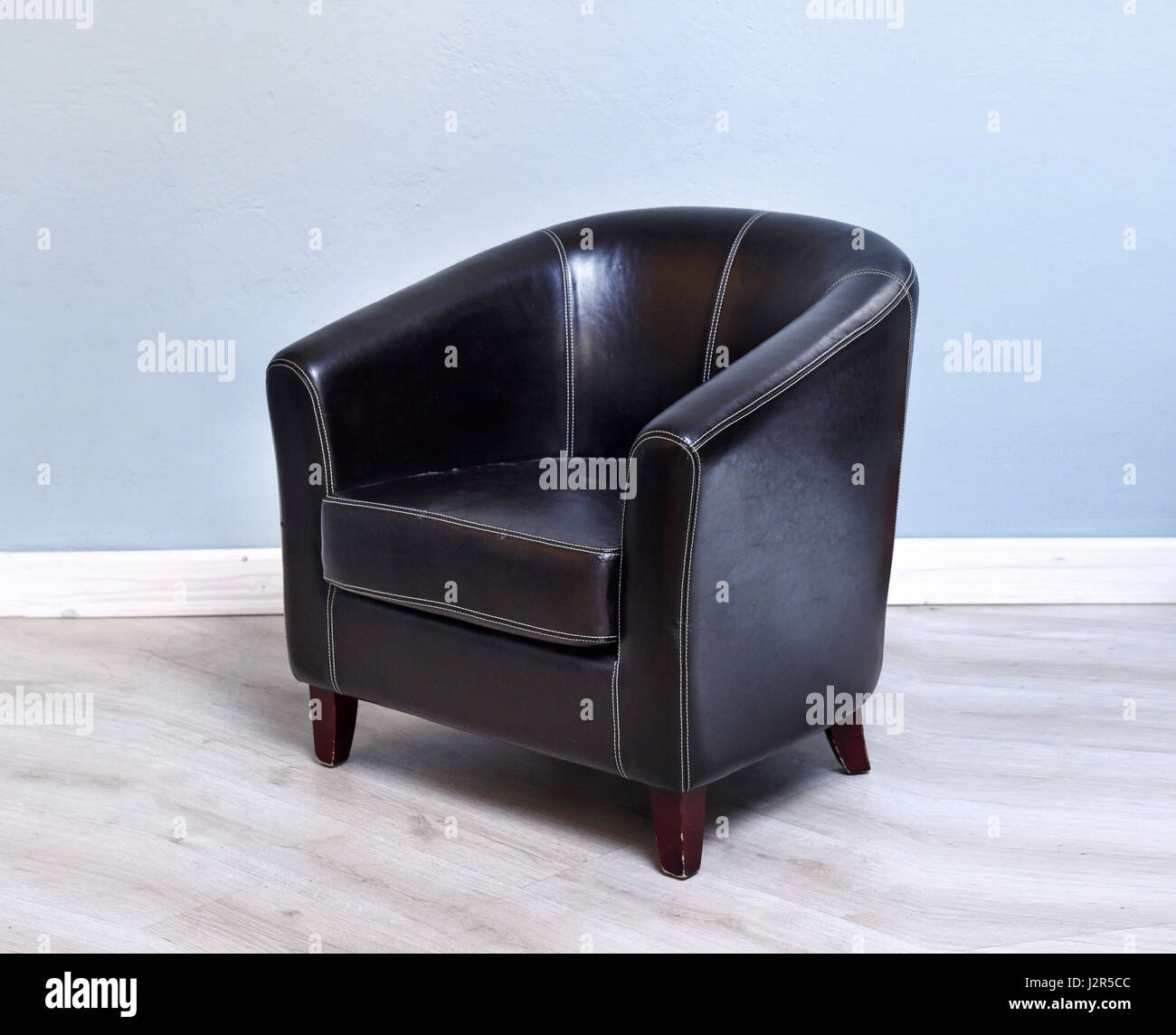 Stylish black leather armchair in a modern room Stock Photo Alamy