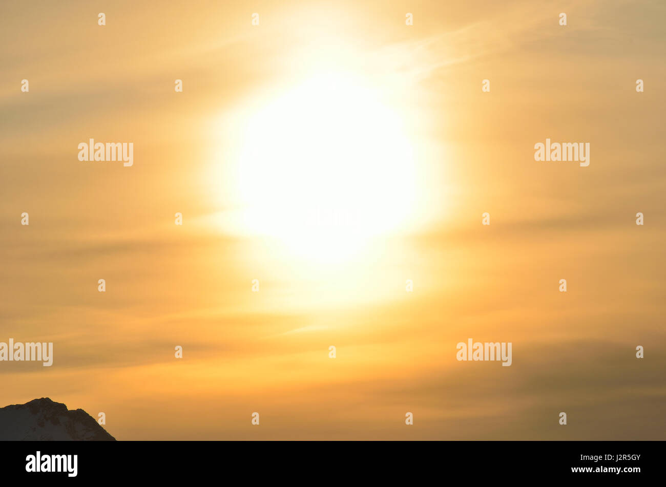 huge golden sunset over snowy mountain peak background Stock Photo - Alamy