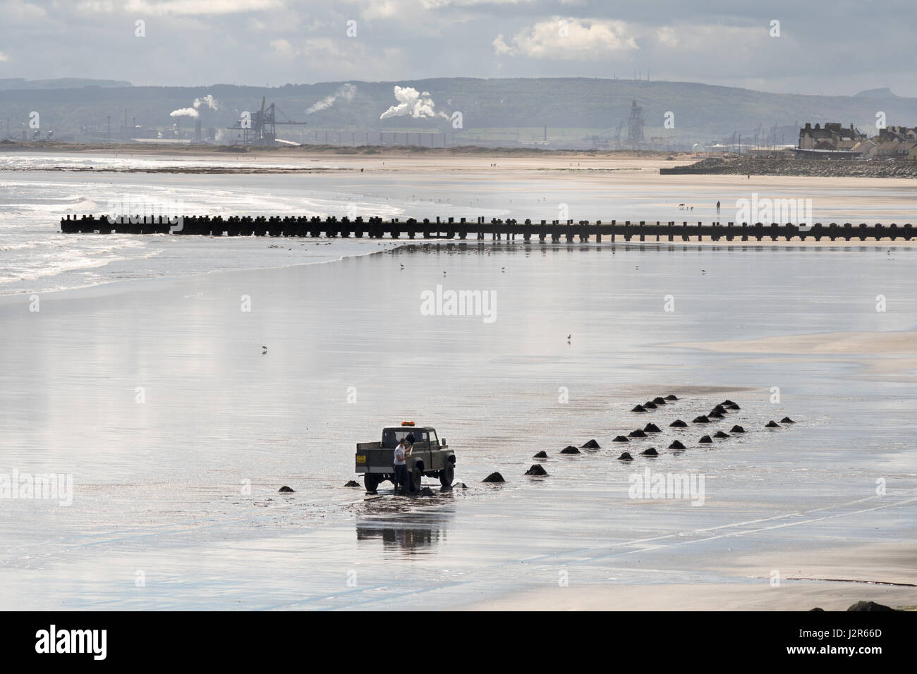 Man collecting sea coal, Seaton Carew, Hartlepool, England, UK Stock Photo